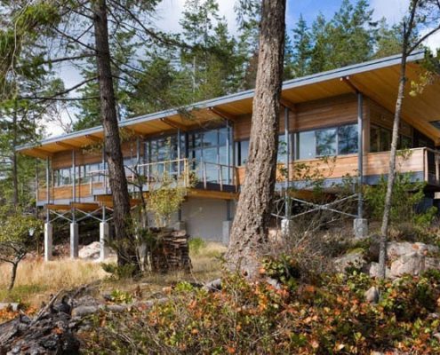 Wall of glass in modern home overlooking the water