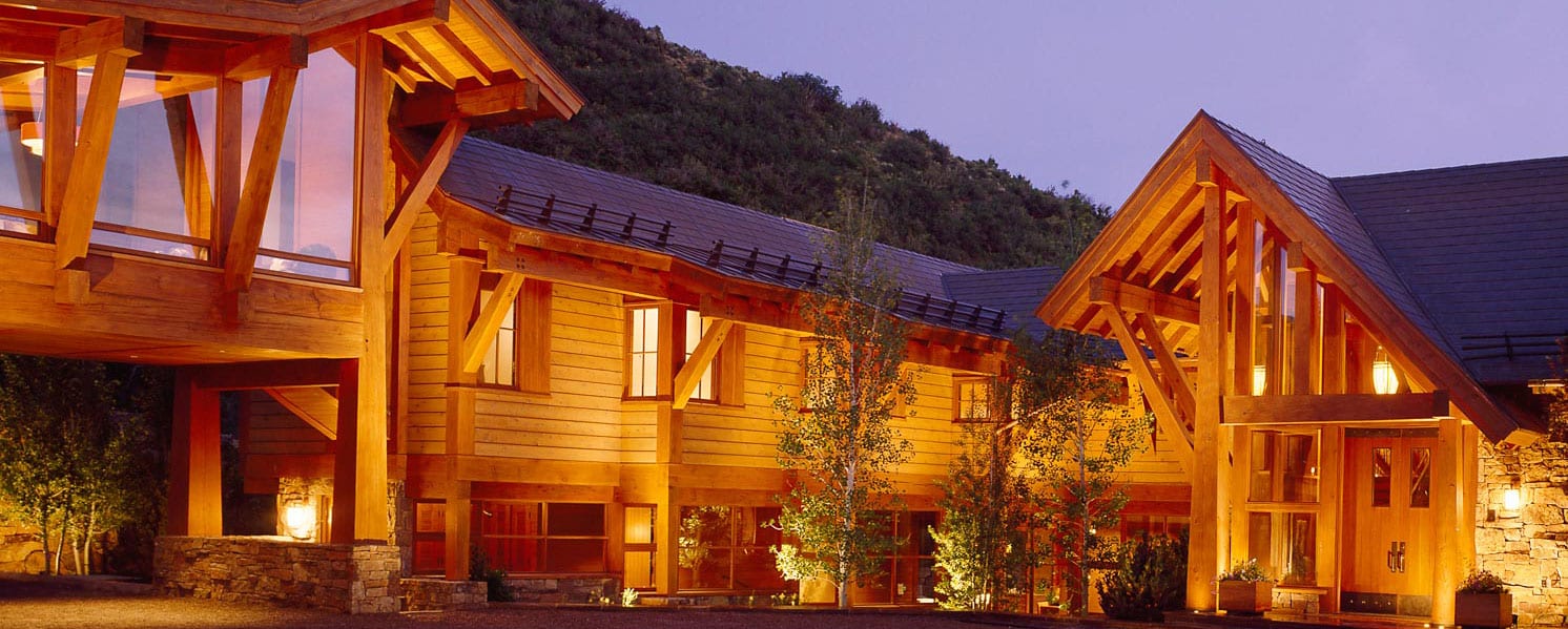 Aspen lodge retreat with modern wood awning windows, night view