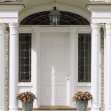 Wooden panel entry door with leaded glass overlay sidelites