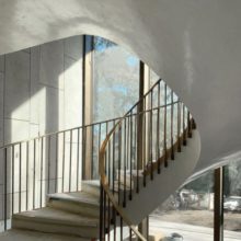 Curving staircase framed by bronze windows in background Curving staircase framed by bronze windows in background