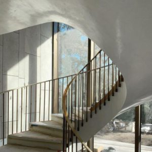 Curving staircase framed by bronze windows in background