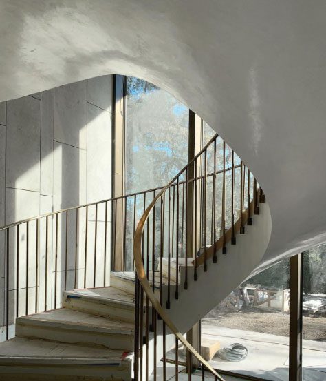 Curving staircase framed by bronze windows in background