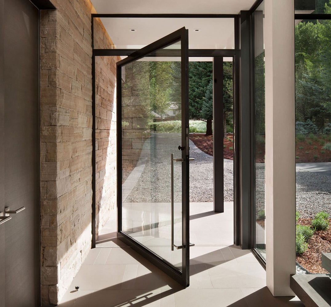 Steel Pivot Door-1076x1000 Massive glass and steel pivot door in entryway