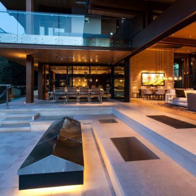steel lift and slide doors open, exterior view looking into dining area at dusk