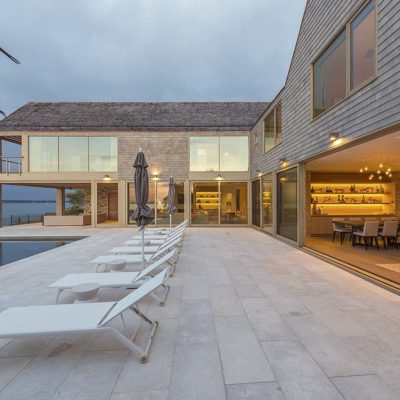 Large multi-panel wood sliding patio doors in home overlooking the sea Large multi-panel wood lift & slide doors in home overlooking the sea