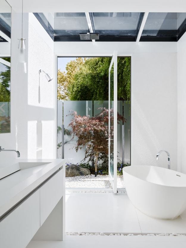Wood and glass pivot opening the bathroom to outdoors