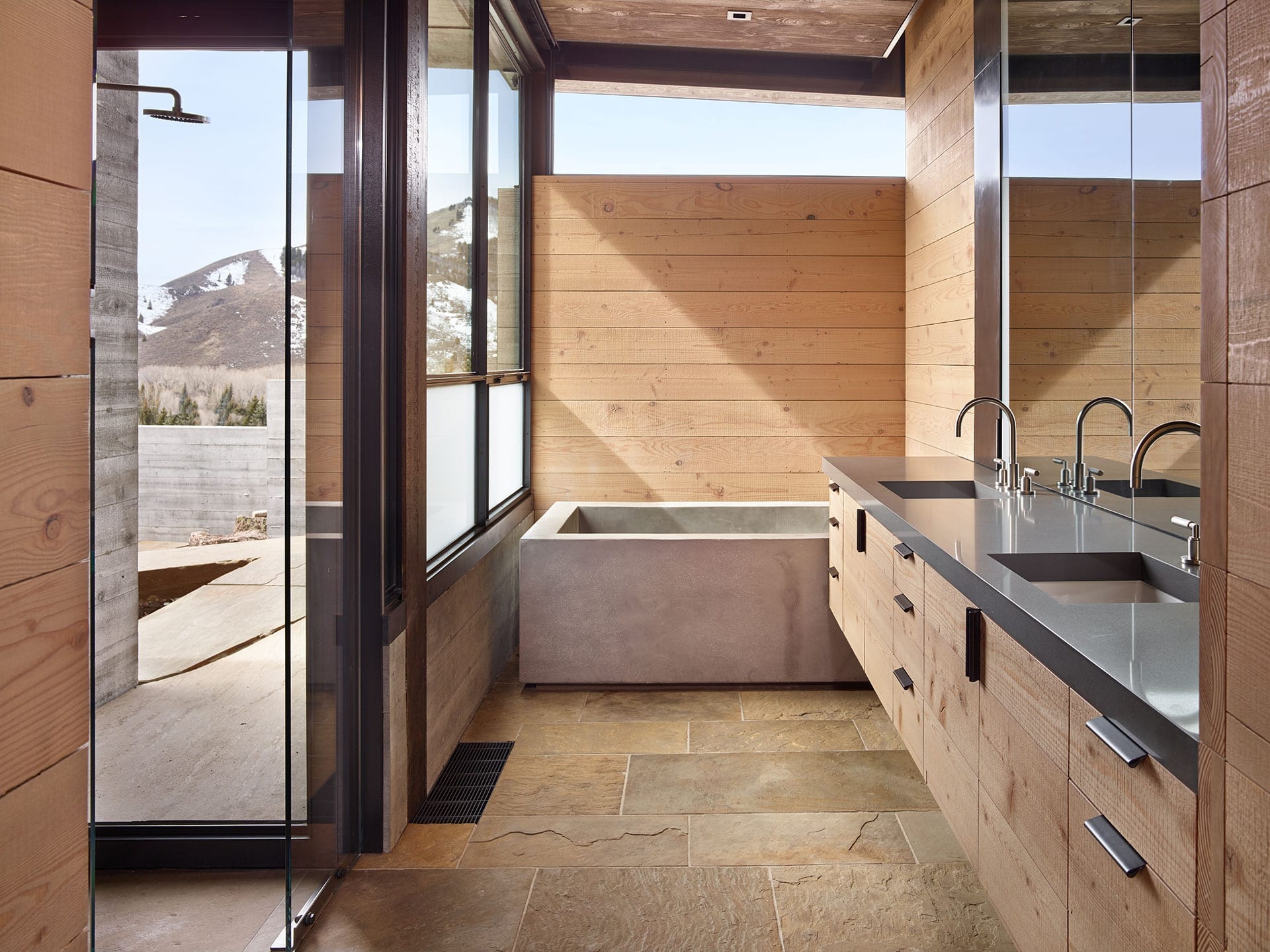 Modern bathroom with concrete style tub and steel windows