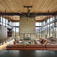 Metal framed residential storefront windows surround living room in mountain home Metal framed residential storefront windows surround living room in mountain home
