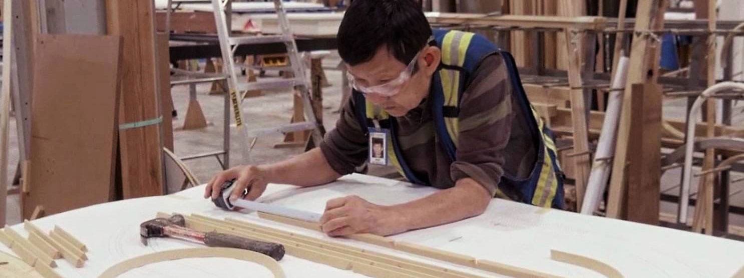 Window factory worker calculating lengths for custom wood windows