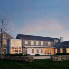 WR Residence at twilight Interior-lit luxury home with custom wood windows at twilight