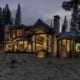 Exterior night view of modern mountain home with tall wood windows
