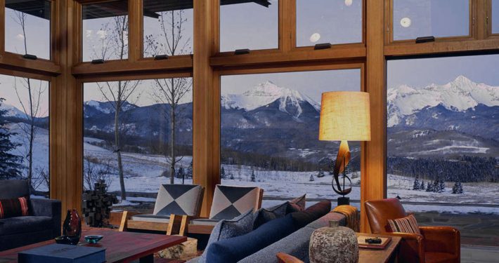 Looking through large custom wooden windows to reveal a beautiful mountain landscape.