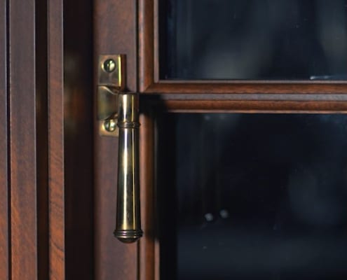 Burnishe bronze cam handle hardware on mahogany window