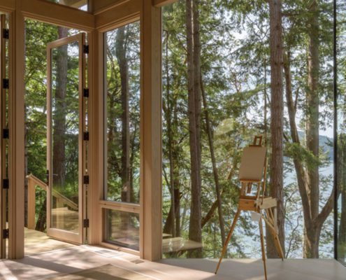 Looking out of a beautiful modern mountain home with floor to ceiling custom glass windows.