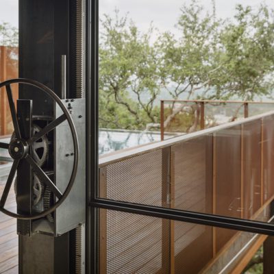 hand operated wheel with exposed counterweights to lower massive window wall