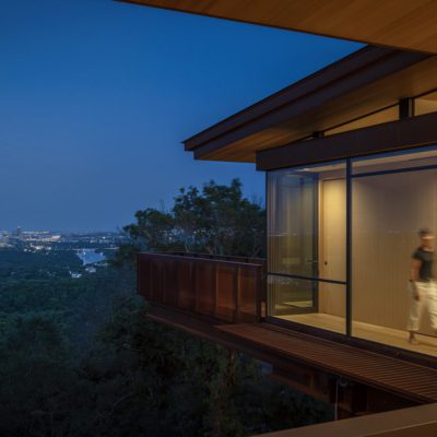 woman walking along lighted enclosed catwalk overlooking Austin