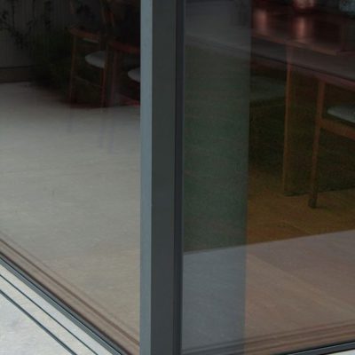 Frameless sliding glass door exterior corner closeup