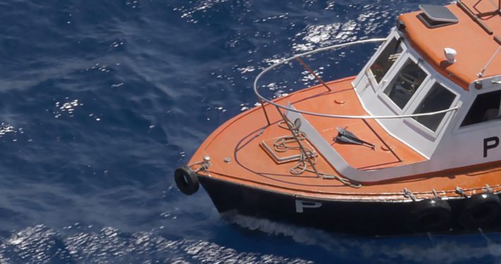 Harbor pilot ship floats in the water waiting to guide a ship into shore